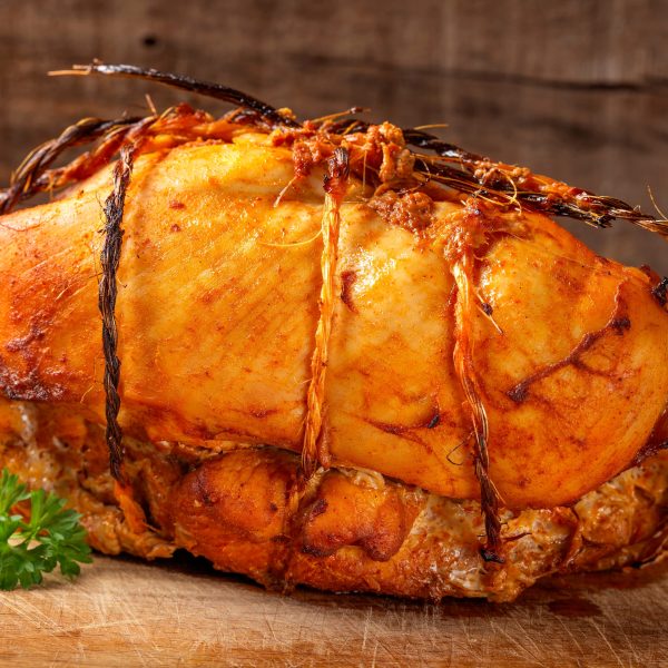 Chicken roll and a curly parsley leaf Chicken roll and a curly parsley leaf on wood